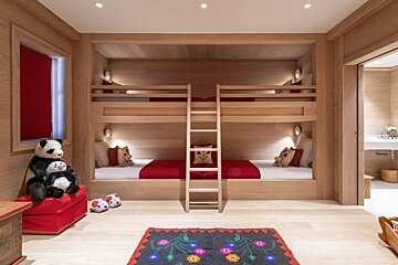 A bedroom with bunk beds and a rug with flowers on it