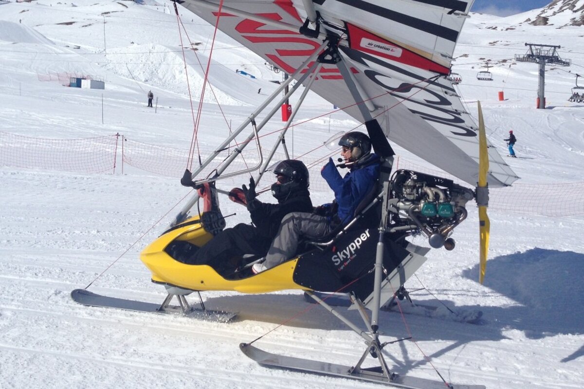 two people with helmets seat in a microlight