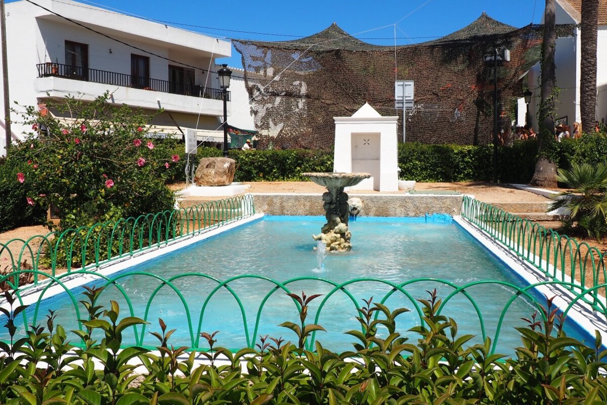 A pool adn fountain in the centre of a village in ibiza
