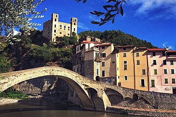A bridge over a river with a castle in the background