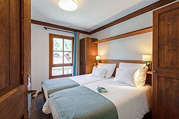 A hotel room with two beds and a window