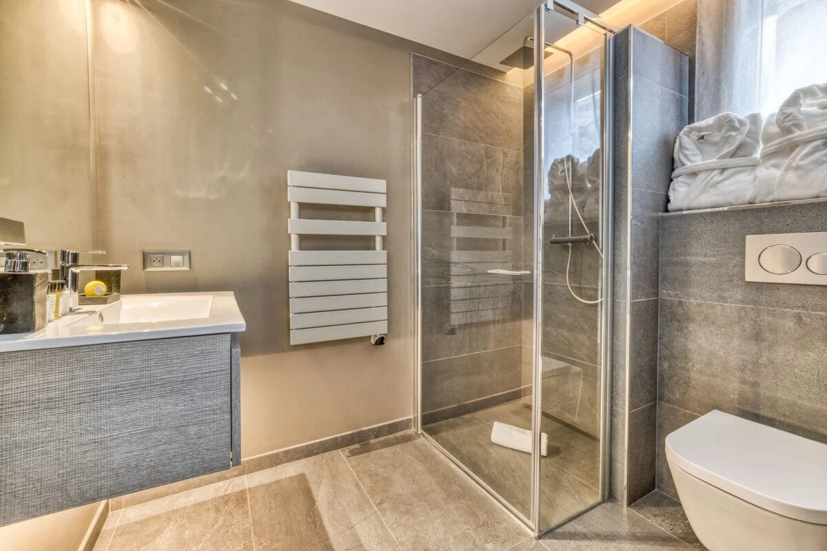 A bathroom with a walk in shower and a toilet