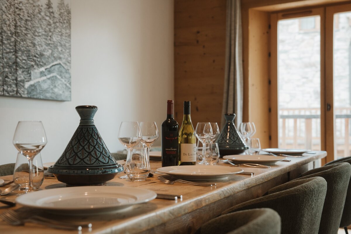 A table set with plates glasses and bottles of wine including a bottle of le chateau