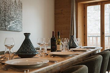 A table set with plates glasses and bottles of wine including a bottle of le chateau