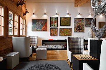 A room with chairs and paintings on the wall