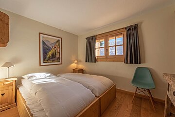 A bedroom with two beds and a picture on the wall that says chamonix passant