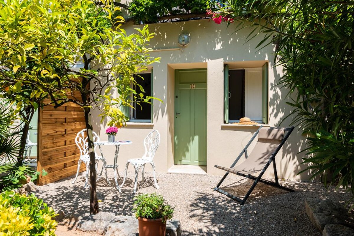 A small patio with a table and chairs in front of a house