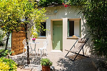 A small patio with a table and chairs in front of a house