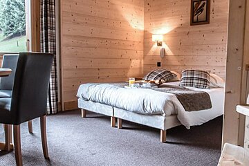 A bedroom with a table and chairs and a bed