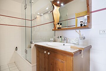 A bathroom with a sink a mirror and a bathtub