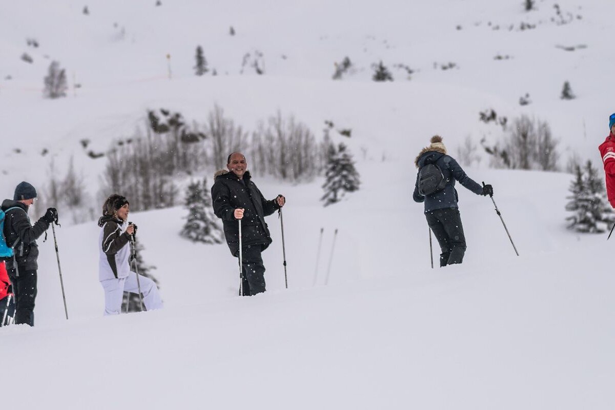 A group of people are walking through the snow