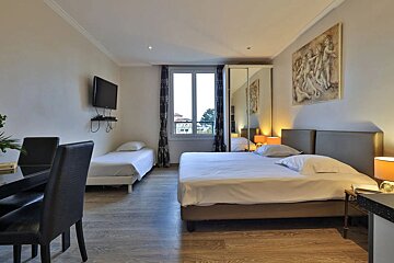 A hotel room with two beds and a flat screen tv