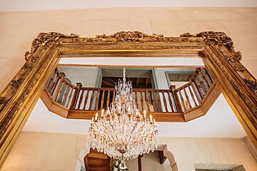 A chandelier is hanging from the ceiling in front of a mirror