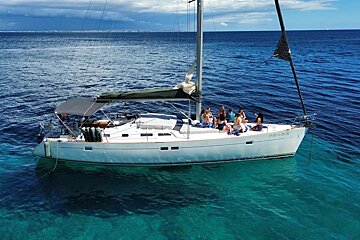 A group of people are gathered on a sailboat named paradise