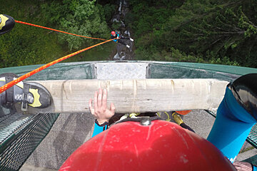 canyoneers rapelling off a bridge