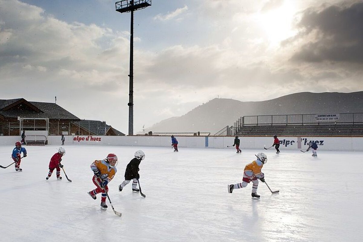 Children playing ice hockey on the outdoor rink patinoire in Alpe d'Huez