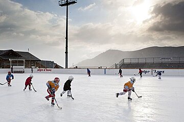 Children playing ice hockey on the outdoor rink patinoire in Alpe d'Huez