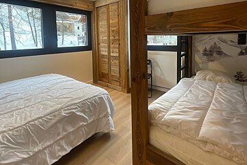 A bedroom with a bunk bed and a window