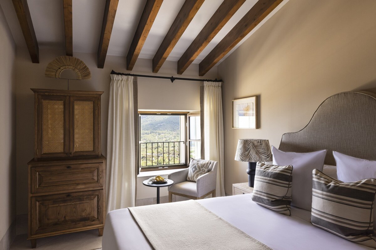 A bedroom with a bed a chair and a window