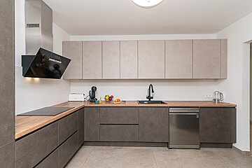 A kitchen with stainless steel appliances and wooden counter tops