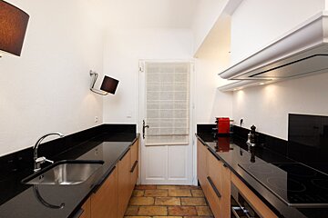 A kitchen with black counter tops and wooden cabinets