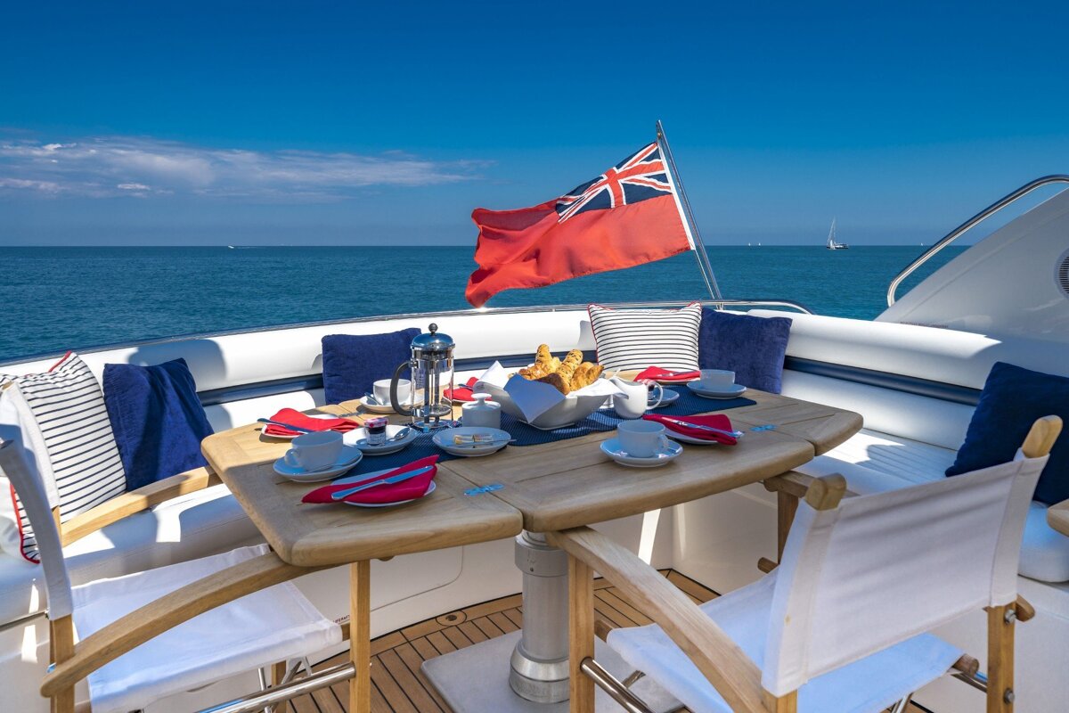 A british flag is flying over a table on a boat