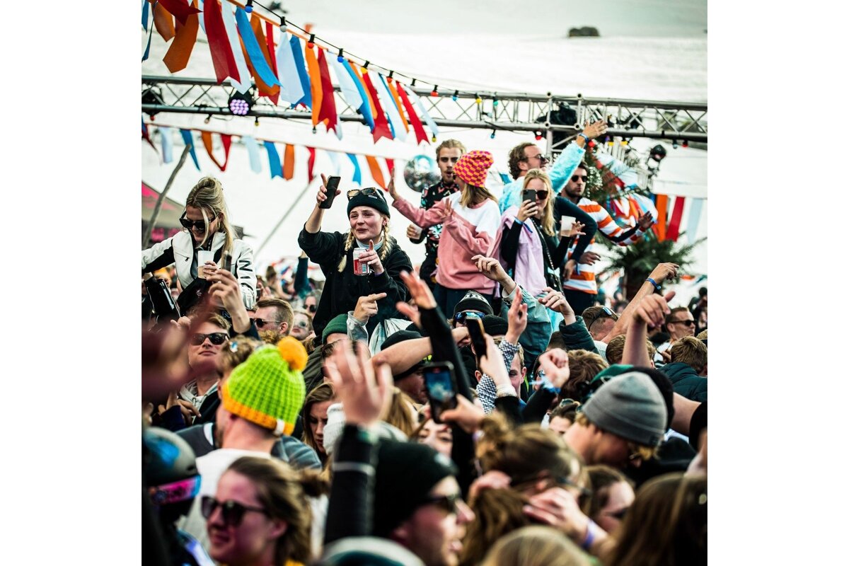 A crowd of people with one wearing a white shirt that says ' ni ' on it