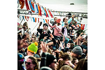 A crowd of people with one wearing a white shirt that says ' ni ' on it
