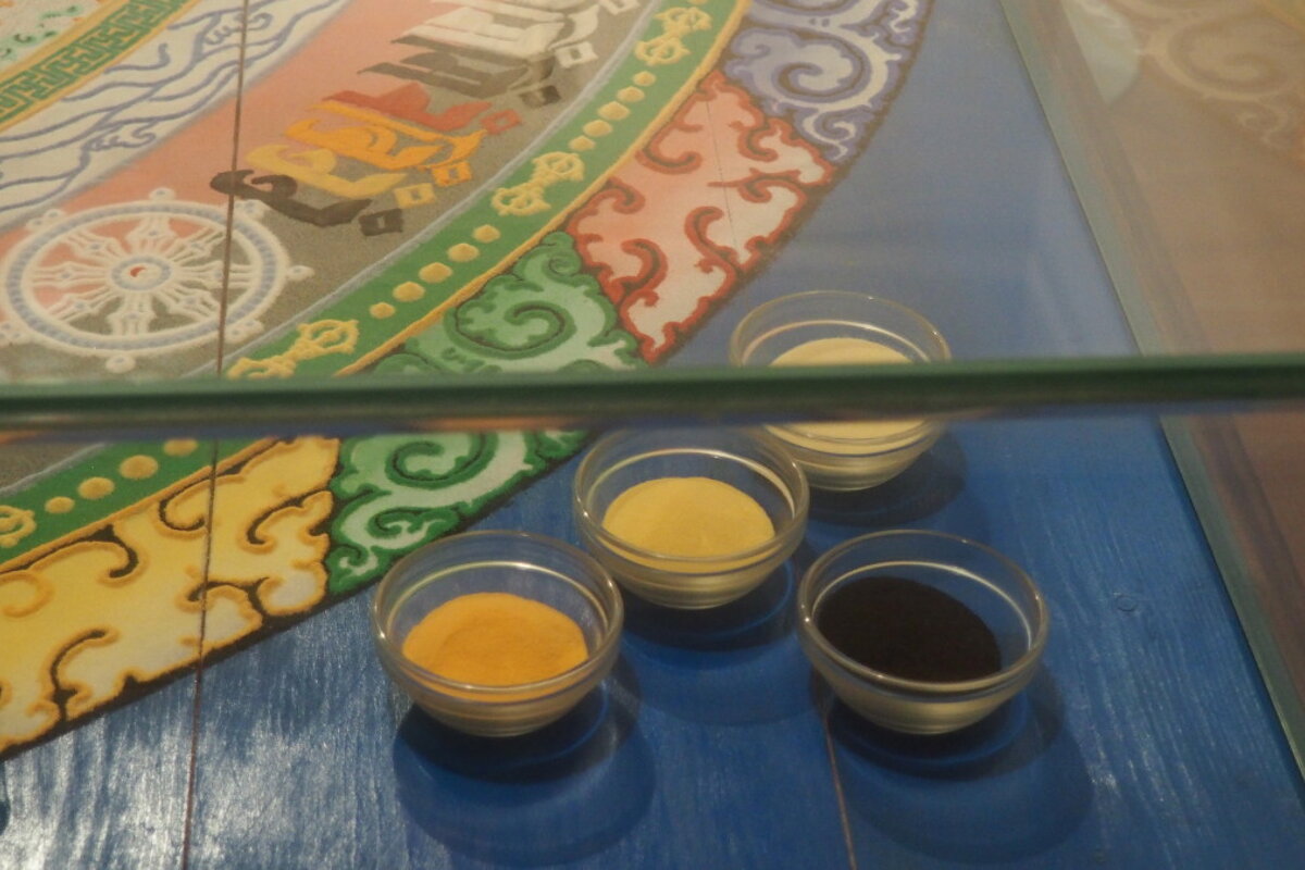 pots of coloured sand in a display case