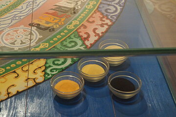 pots of coloured sand in a display case