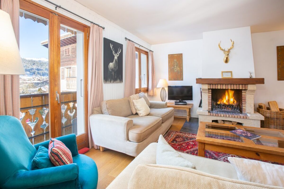 A living room with a fireplace and a painting of a deer on the wall