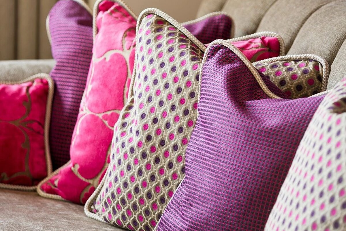 A couch with pink and purple pillows on it