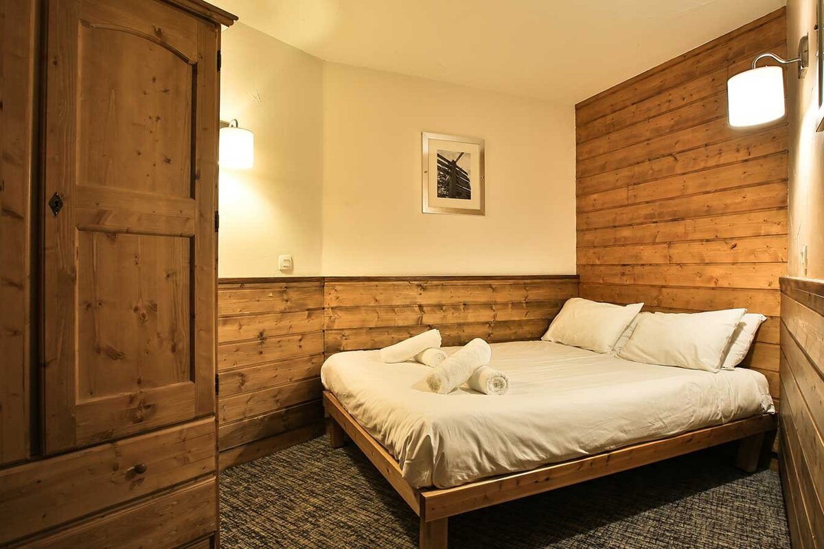 A bedroom with a bed and a picture on the wall