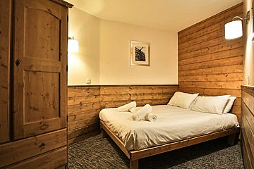 A bedroom with a bed and a picture on the wall