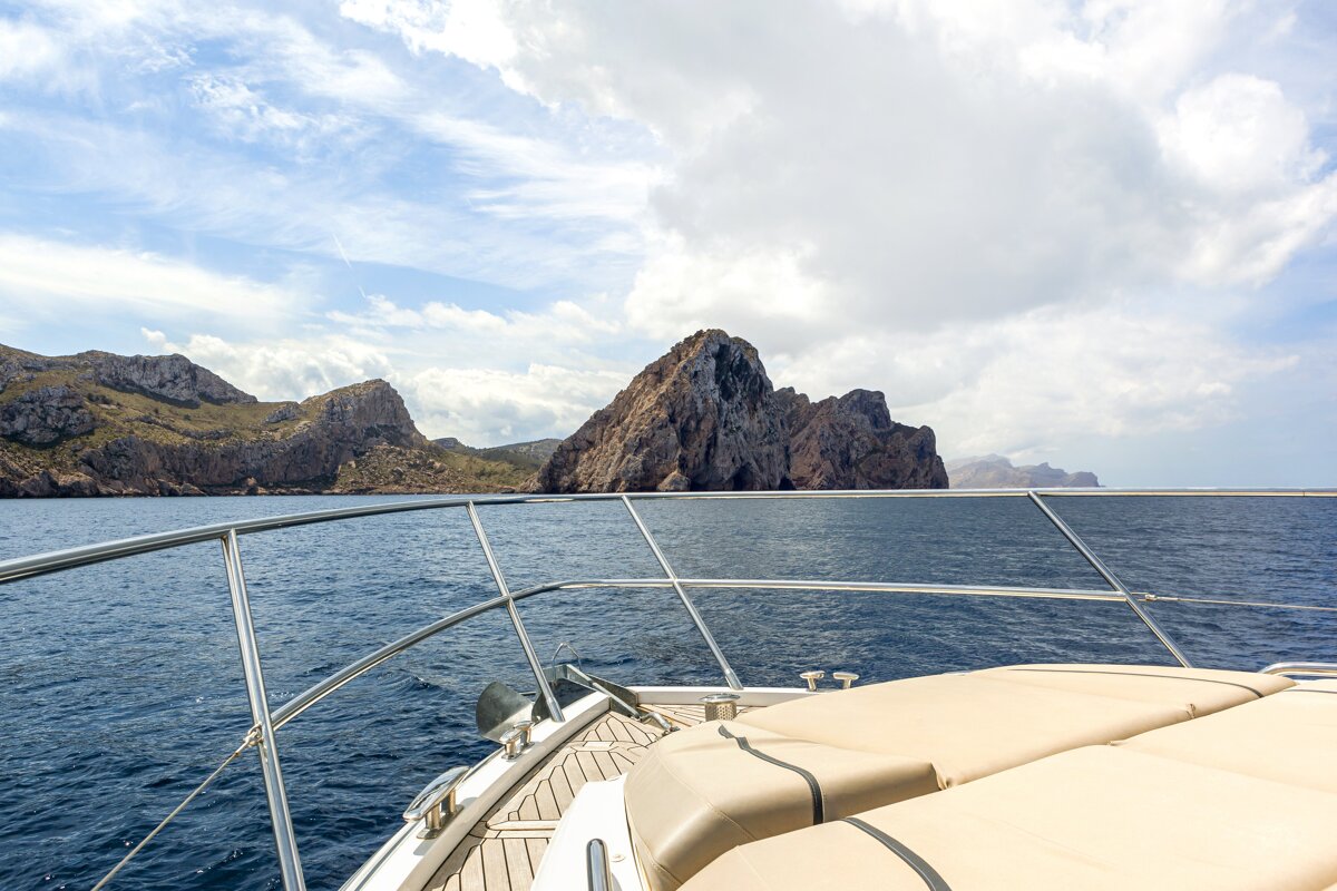 A boat in the ocean with mountains in the background