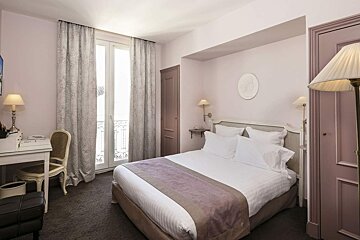 A hotel room with a bed and a desk