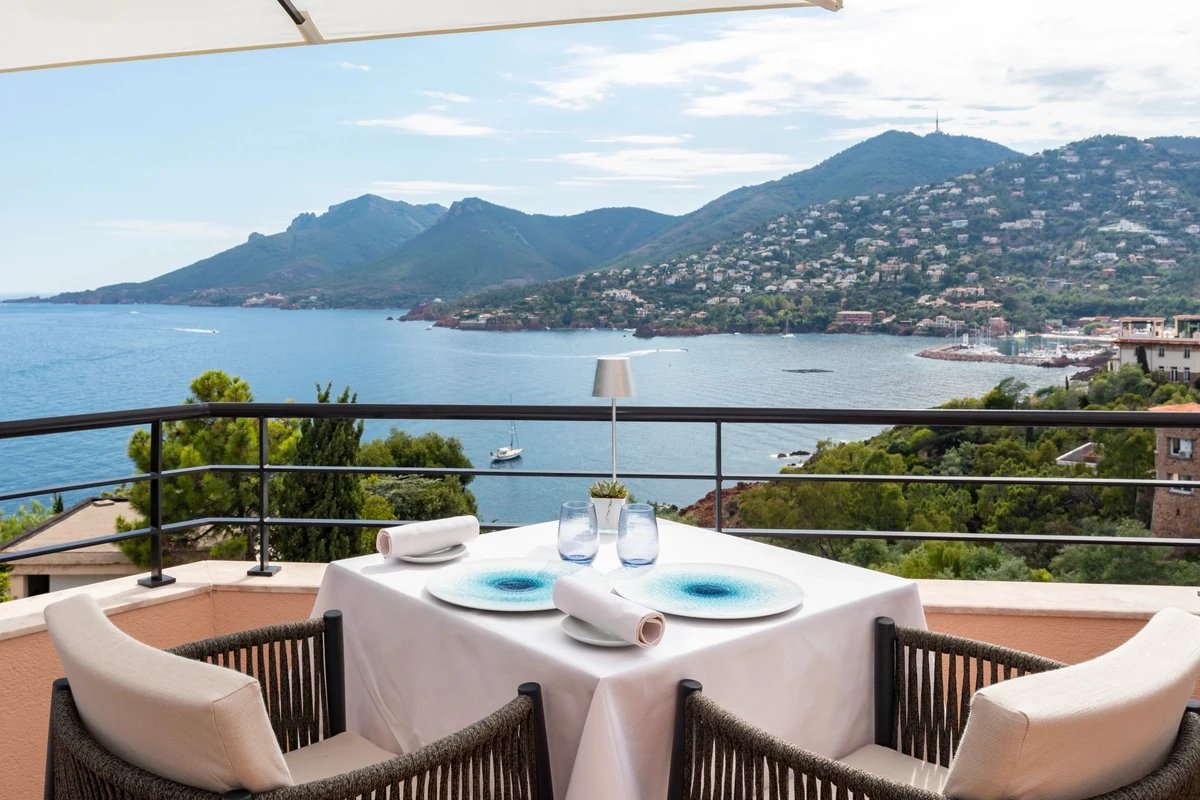 A balcony with a view of the ocean and mountains