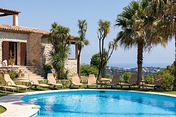 A large swimming pool surrounded by chairs and palm trees