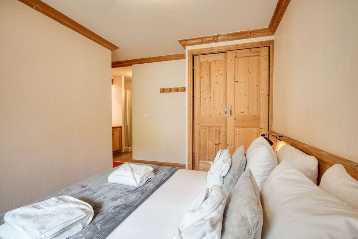 A bedroom with a bed and a wooden door
