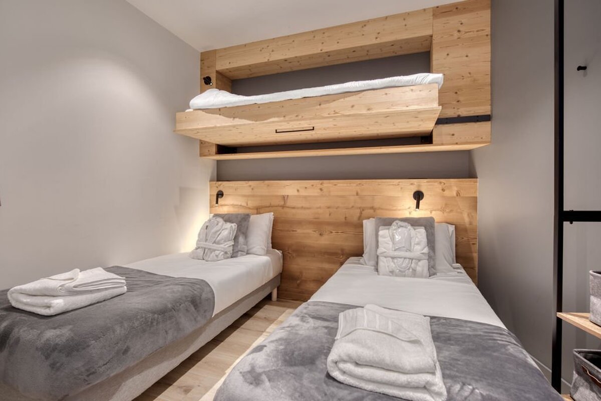 A bedroom with two beds and a bunk bed
