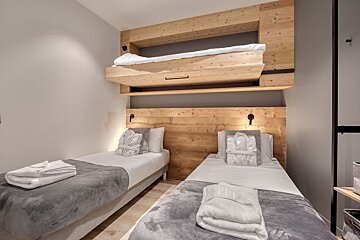 A bedroom with two beds and a bunk bed