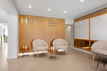 Modern, inviting hotel lobby or waiting area with a wood-paneled wall, 