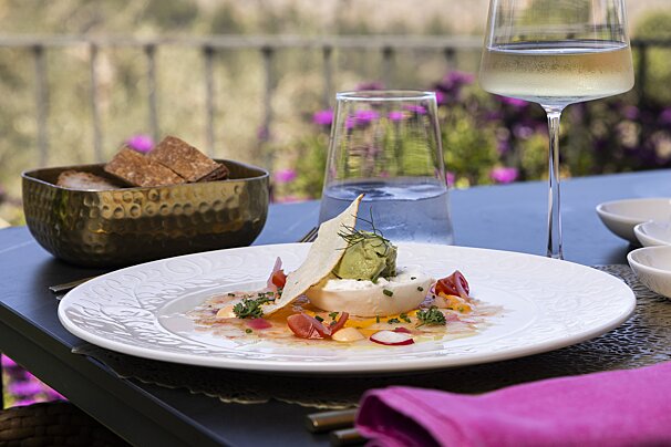 A plate of food and a glass of wine on a table