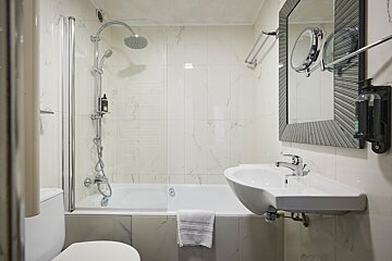 A bathroom with a sink a toilet and a bathtub