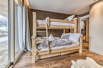 A bunk bed in a room with a sliding glass door
