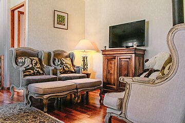 A living room with two chairs and a flat screen tv