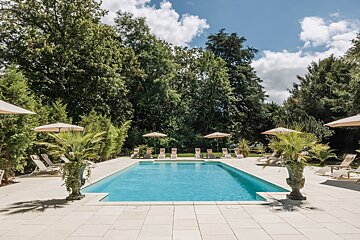 A large swimming pool surrounded by chairs and umbrellas