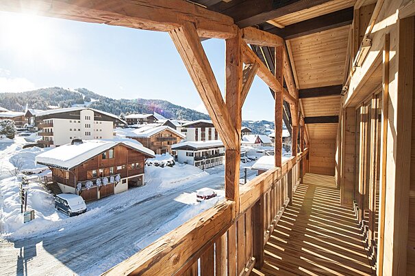 A balcony with a view of a snowy village