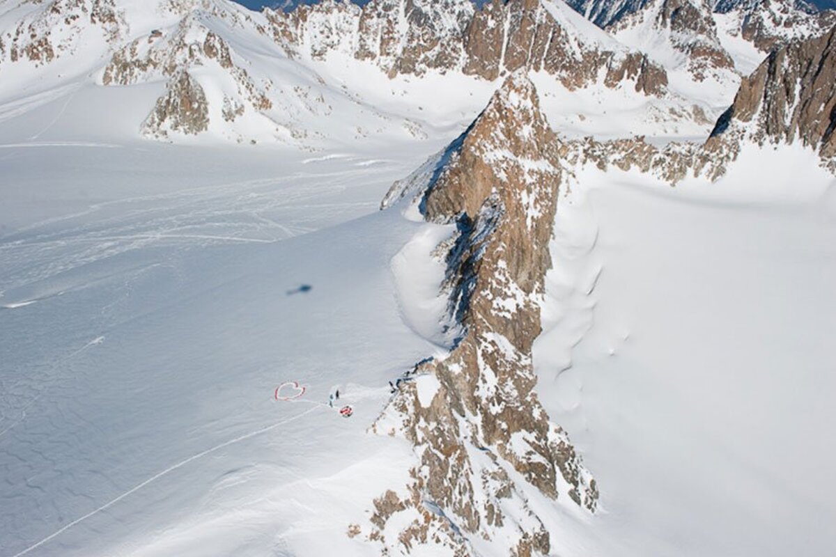 An aerial view of a snowy mountain with a red circle in the middle
