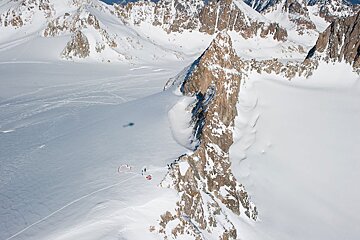 An aerial view of a snowy mountain with a red circle in the middle